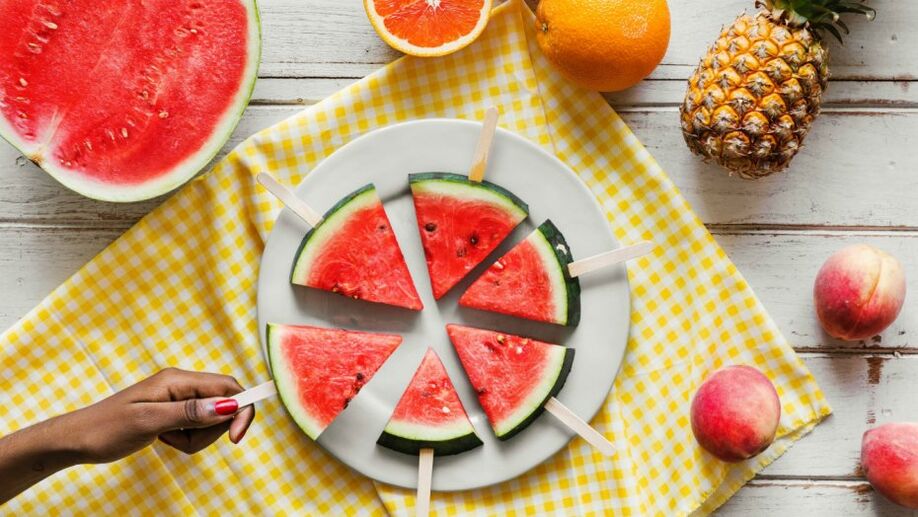 Rebanadas de sandía colgando de un palo